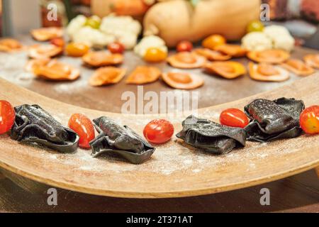 Schwarze italienische Nudeln auf der Vorderseite und orange Kürbisnudeln auf der Rückseite. Mehrfarbige Pasta aus Gemüse. Stockfoto