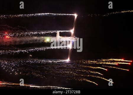 Avión lanzando fuegos artificiales por la noche Stockfoto