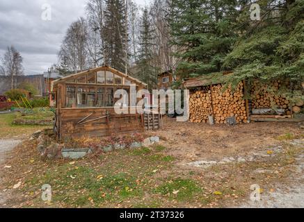 Gewächshaus mit einem überdachten Holzhaufen in Dawson City, Yukon, Kanada Stockfoto