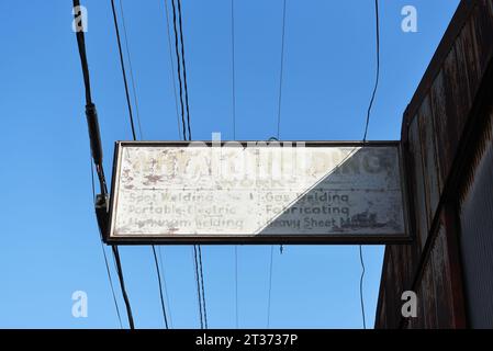 LONG BEACH, KALIFORNIEN - 18. OCT 2023: Verblichenes und rostiges Schild am Whyatt Welding Works Gebäude. Stockfoto