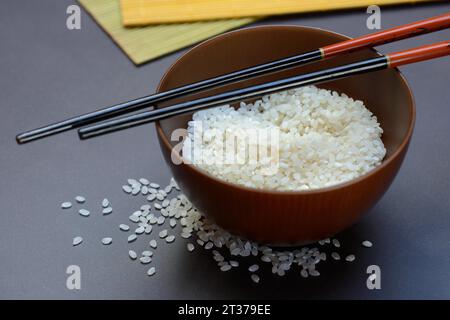 Reis, weißer Reis in einer Schüssel mit Holzkelle, ungekocht Stockfoto