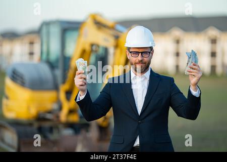 Buider-Mann in Anzug und Schutzhelm. Bauinvestor. Geschäftsmann-Investor vor der Baustelle. Erfolgreicher Investor. Ein hübscher Mann im Anzug Stockfoto