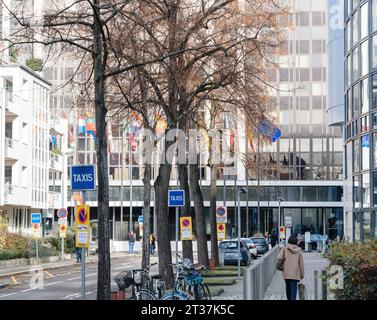 Straßburg, Frankreich - 22. November 2023: Entlang einer Straße ist ein Taxischild sichtbar, im Hintergrund befindet sich das Winston Churchill-Gebäude des Europäischen Parlaments. Stockfoto