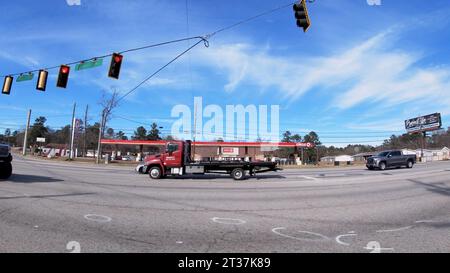 Augusta, GA USA - 01 19 22: POV Fahren auf der Straße Pan einen roten Abschleppwagen im Verkehr Stockfoto