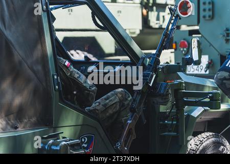 Konzentrieren Sie sich auf das universelle polnische Maschinengewehr UKM-2000, das sich neben einem polnischen Soldaten auf ein modernes Militärfahrzeug stützt. Hochwertige Fotos Stockfoto