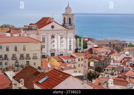 Skyline-Blick auf die Kirche Igreja de Santo Estêvão im barocken Stil des Viertels Alfama und den Fluss Tejo in Lissabon, Portugal. Stockfoto