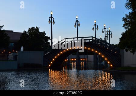 Eine Fußgängerbrücke im Louis Armstrong Park wird vor dem Nachthimmel in New Orleans beleuchtet Stockfoto