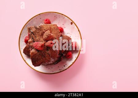 Teller mit Himbeer-Schokoladen-Brownie auf pinkfarbenem Hintergrund Stockfoto