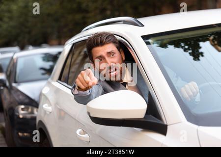 Wütender Fahrer, der jemanden aus dem Auto im Stau anschrie Stockfoto