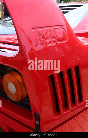 Die unverwechselbare aerodynamische Heckflügelstrebe, das eingebuchte Emblem, die Lamellen und die Heckleuchten eines Ferrari F40 Supersportwagens, die auf einer italienischen Automobilausstellung ausgestellt wurden. Stockfoto