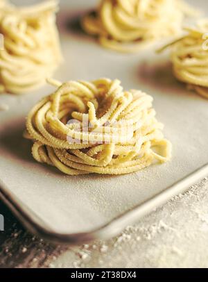 Körbe frischer Spaghetti auf Tablett isoliert Stockfoto