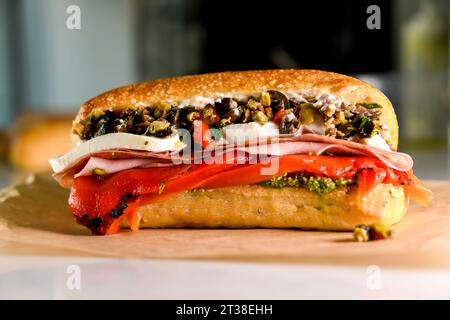 Italienisches Sandwich mit Oliven-Tapenade, Büffel, Mozzarella, gebratenen roten Paprika, Pesto, frische knusprige Rolle Stockfoto
