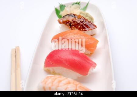Sushi-Platte mit Chopstix auf weißem Hintergrund Stockfoto