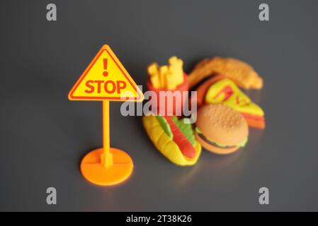 Nahaufnahme von STOPPSCHILDERN und Junk Food. Hören Sie auf, ungesunde Lebensmittel zu essen Konzept. Stockfoto