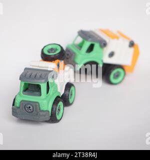 DIY-Kunststoff-Truck-Spielzeug isoliert auf weiß. Schwerlastfahrzeug schleppt beschädigten Müllwagen ab. Das selbstgebaute Spielzeug steigert die Kreativität der Kinder. Stockfoto