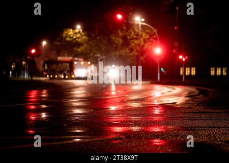 Oldenburg, Deutschland. Oktober 2023. Die roten Ampeln einer Ampel reflektieren am frühen Morgen auf der nassen Fahrbahn der Kreuzung am Pferdemarkt. Quelle: Hauke-Christian Dittrich/dpa/Alamy Live News Stockfoto