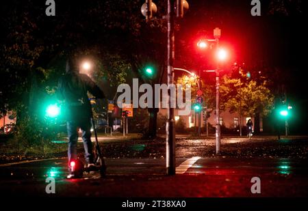 Oldenburg, Deutschland. Oktober 2023. Ein junger Mann steht am frühen Morgen bei regnerischem Wetter vor einer roten Ampel an der Kreuzung am Pferdemarkt. Quelle: Hauke-Christian Dittrich/dpa/Alamy Live News Stockfoto