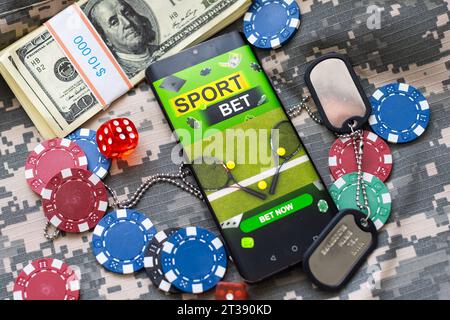Kreativer Hintergrund, Online-Casino, in der Hand eines Mannes ein Smartphone mit Spielkarten, Roulette und Chips, schwarz-goldener Hintergrund. Internet-Glücksspiel Stockfoto