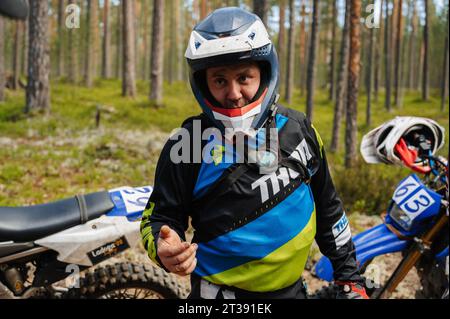 REPUBLIK KARELIEN, RUSSLAND - CA. JUNI 2022: Offroad-Turnier Ladoga Trophy 2022 in Karelien. Motorradfahrer in einem Helm auf Sportmotorrädern vor dem Start des Rennens Stockfoto