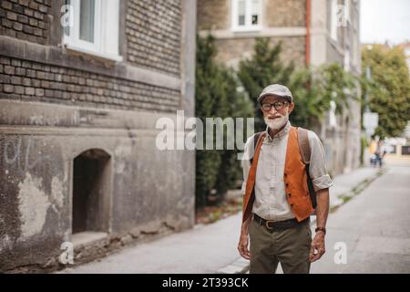 Porträt eines gutaussehenden älteren Mannes in einer Stadt. Älterer cooler Mann, der in modischen Kleidern durch die Stadt schlendert. Stockfoto
