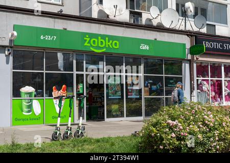 Schild des polnischen Lebensmittelgeschäfts ZABKA Cafe. Supermarkt mit grünem Schild. Hausfassade. Straßengeschäft. Warschau, Polen - 26. Juli 2023. Stockfoto