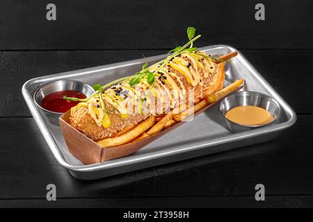 Geräucherte Wurst Maishund mit Pommes frites, süßem Chili und Cheddar-Saucen Stockfoto