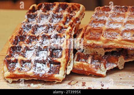 Viele frisch zubereitete belgische Waffeln mit Puderzucker. Stockfoto