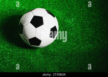 Ein klassischer schwarz-weißer Fußball, isoliert auf grünem Gras, von oben gesehen. Stockfoto