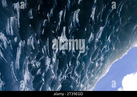 Nahaufnahme der komplexen Eisformationen an einer Höhlendecke mit einem Hauch von Himmel in der Ecke. Stockfoto