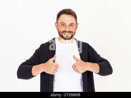 Junger, gutaussehender Mann mit Bart, der legere Kleidung auf weißem Hintergrund trägt, der positive Gesten mit der Hand, Daumen hoch, akzeptiert. Mann lächelt und hap Stockfoto
