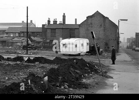 Contracters und Polizisten transportieren Reisende und ihre Karawanen aus dem Brachland während der Slumräumung von St. Ann's, Nottingham. 1969-1972 Stockfoto