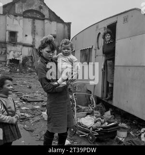 Mutter und vier Kinder außerhalb ihrer Reisekarawane auf Ödland während der Slumräumung und Abriss von St. Ann's, Nottingham. 1969-1972 Stockfoto