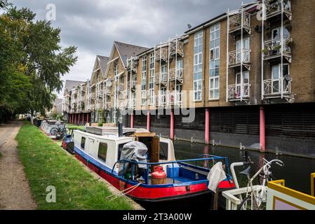 Schmalboote und Sozialwohnungen entlang des Grand Union Canal, Paddington Arm in West London, England, Großbritannien Stockfoto