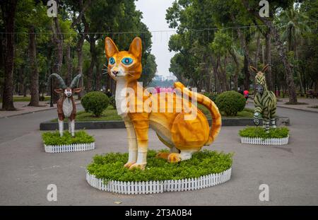 Eine große gelbe Modellkatze mit blauen Augen im Wiedervereinigungspark in Hanoi, Vietnam, um das Mondneujahr der Katze im Januar 2023 zu begrüßen Stockfoto