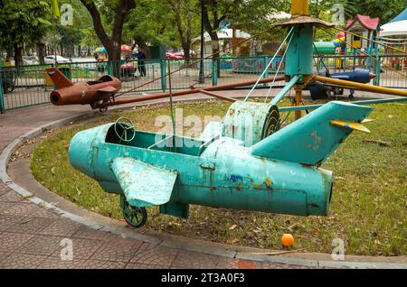 Ein sehr altes und verblüfftes Kinderkarussell mit rostigen Metalljets, die von einem großen Fan, Hanoi, Vietnam, angetrieben werden Stockfoto