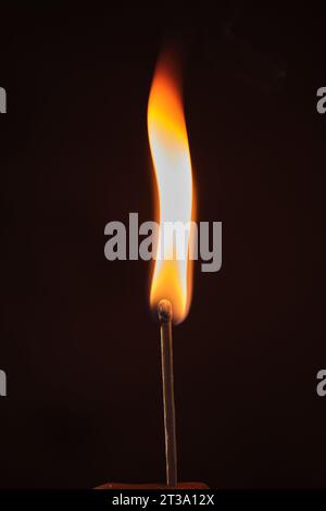 Ein beleuchtetes Streichholz auf dunklem Hintergrund Stockfoto