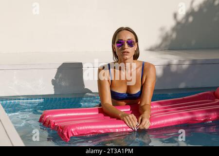 Summer Vibes: Frau genießt Poolzeit in Pink Float Stockfoto