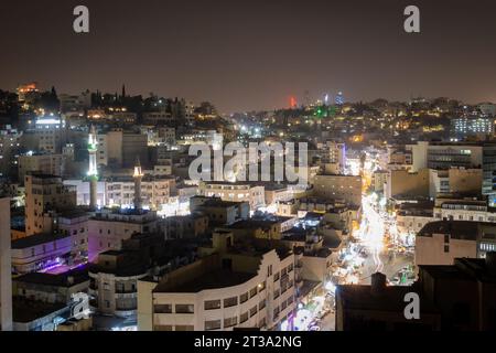 Lange Sicht auf das beleuchtete Amman, Jordanien bei Nacht vor dunklem Himmel Stockfoto