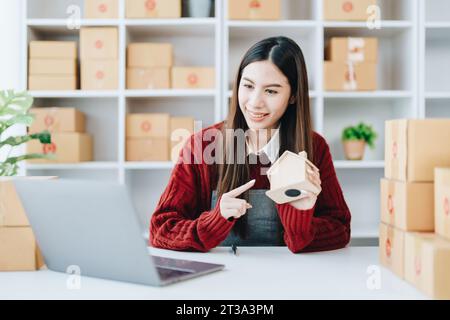 Schöne asiatische Frau, Bloggerin, Blog, Präsentation der Produktqualität, Live-Video, soziale Medien, Aufnahme, Online-Verkauf über Digitalkameras, kmu oder kleine Unternehmen Stockfoto