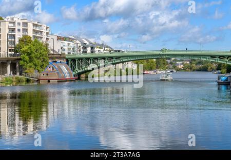 Ungewöhnliches Boot namens Vaisseau Odyssee, das am Ufer der Erdre vor Anker liegt. Die Brücke heißt Pont Général de la Motte Rouge. In Nantes, Frankreich. Stockfoto