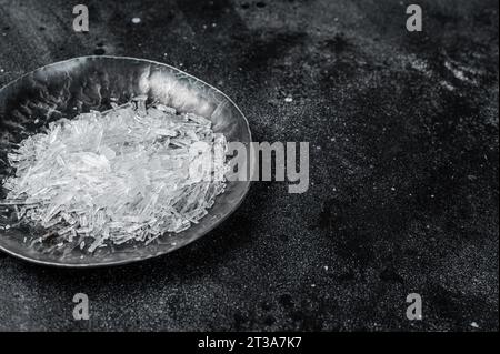 Menthol-Kristalle in einer Stahlkleingeschale. Schwarzer Hintergrund. Draufsicht. Leerzeichen kopieren. Stockfoto