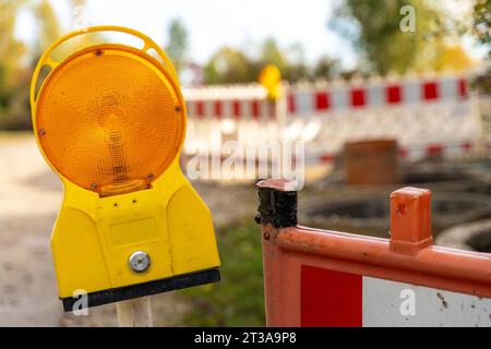 Langweid, Bayern, Deutschland - 23. Oktober 2023: Gelbe Warnleuchte auf einer Baustelle. Baustellenbarriere *** Gelbes Warnlicht an einer Baustelle. Baustellenabsperrung Stockfoto