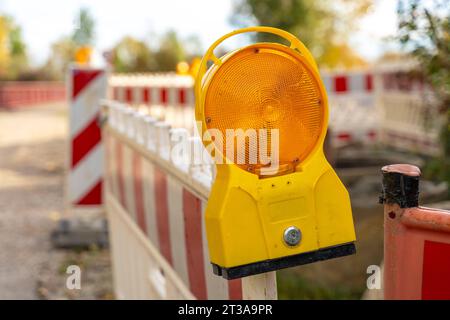 Langweid, Bayern, Deutschland - 23. Oktober 2023: Gelbe Warnleuchte auf einer Baustelle. Baustellenbarriere *** Gelbes Warnlicht an einer Baustelle. Baustellenabsperrung Stockfoto