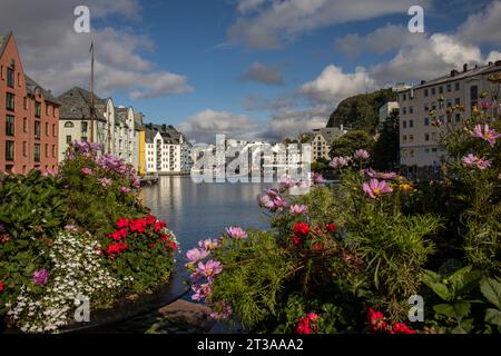 Preciosa imagen del Canal de Alesund con sus edificios Art Noveau y flores en primer plano, Noruega Stockfoto