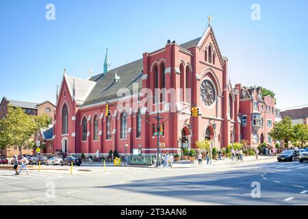 Park Slope, Brooklyn: Holy Family St. Römisch-katholische Kirche Thomas von Aquin, in rot bemalten Backsteinen und weiß bemalten Zierleisten, an der 4th Avenue und 9th Street. Stockfoto