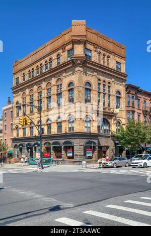 Park Slope, Brooklyn: Acme Hall, ein Gebäude im romanischen Stil mit aufwändigen Ziegelmauern, hohen Fenstern mit Spiegeldach und Eckturm. Stockfoto