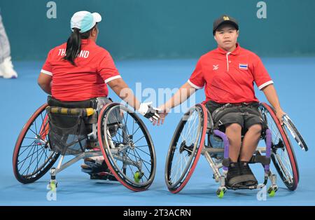 Hangzhou, chinesische Provinz Zhejiang. Oktober 2023. Thailands Sakhon Khanthasit(L)/Thipaksorn Singkeaw klatschte beim Halbfinale der Frauen-Doppelspiele im Rollstuhl-Tennis gegen die Chinesen Guo Luoyao/Zhu Zhenzhen bei den 4. Asiatischen Para-Spielen in Hangzhou, ostchinesische Provinz Zhejiang, 24. Oktober 2023. Quelle: Cai Yang/Xinhua/Alamy Live News Stockfoto