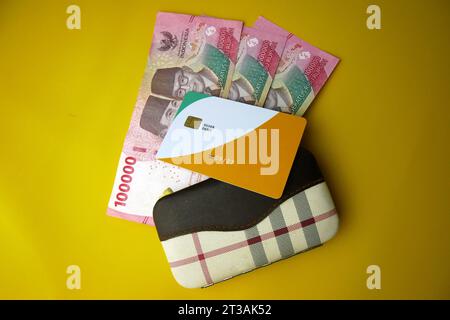 Brieftasche mit Geld auf gelbem Hintergrund. Indonesische Rupiah. Budgetierungskonzept. Kopierbereich Stockfoto