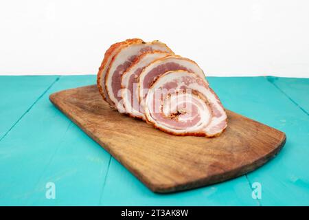 Schweinefleischroulade auf einem Holzschneidebrett geschnitten, Seitenansicht aus nächster Nähe Stockfoto