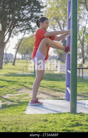 Lateinisches Mädchen, das in einem öffentlichen Park Beine streckt. Stockfoto